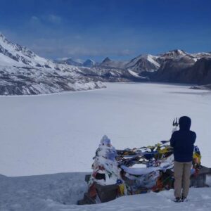 Frozen lake surrounded by mountains with a pilgrim site 