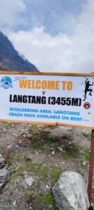 A white and orange sign welcoming visitors to Langtang 
